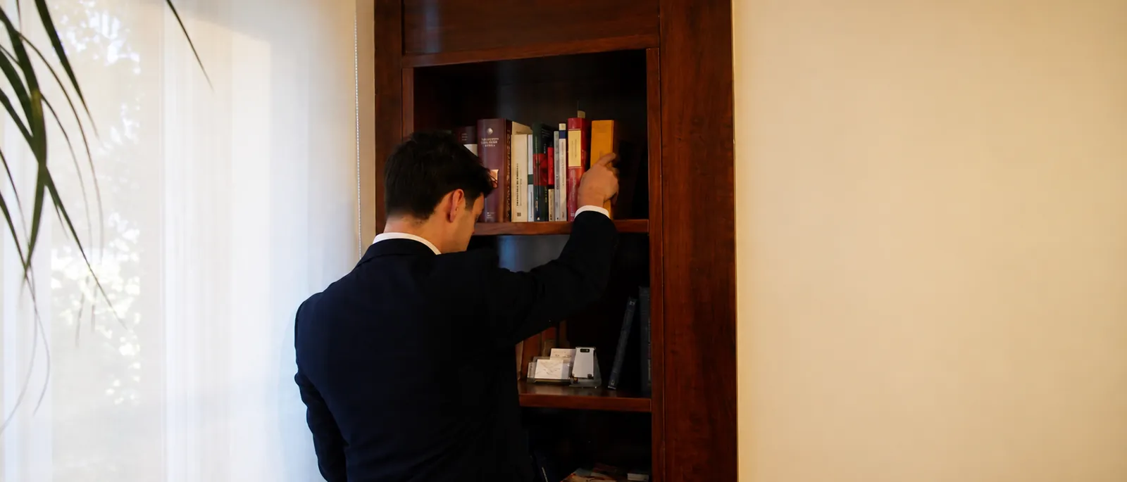 Álvaro Balsa consultando el convenio colectivo en la estantería del despacho, en Madrid